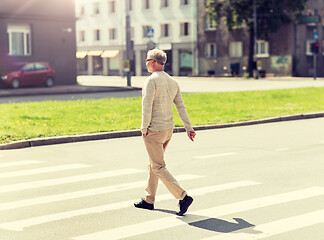 Image showing senior man walking along city crosswalk