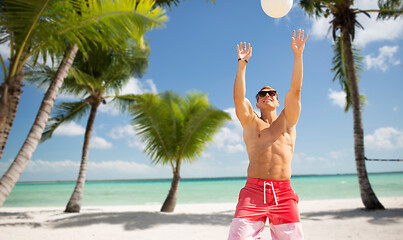 Image showing young man with ball playing volleyball on beach