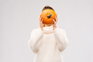 Image showing woman holding pumpkin and covering her face