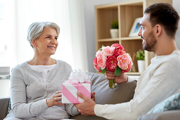 Image showing son giving present and flowers to senior mother