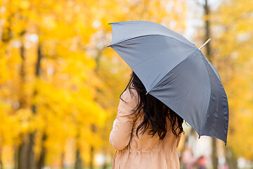 Image showing young woman with umbrella in autumn park