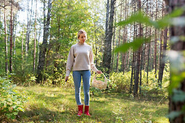 Image showing woman with basket picking mushrooms in forest