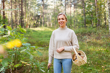 Image showing woman with basket picking mushrooms in forest