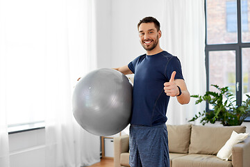 Image showing man exercising with fitness ball at home