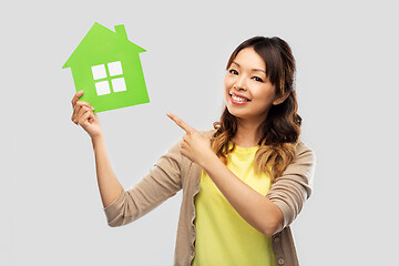 Image showing happy asian woman showing green house