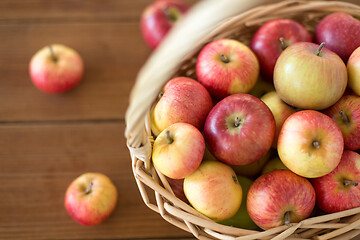 Image showing ripe apples in wicker basket on wooden table