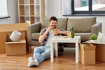 Image showing smiling man eating takeaway food at new home