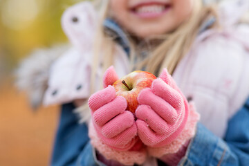 Image showing close up of little girl holding apple in autumn