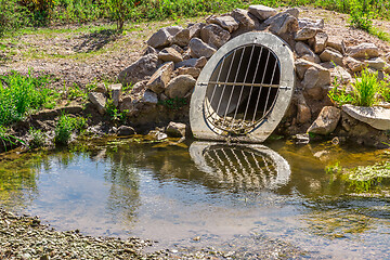 Image showing Water drainage pipe prevening from flooding land.