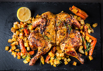 Image showing Butterflied grilled whole chicken with roasted vegetables and potatoes 