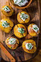 Image showing Oven baked potatoes with sour cream with butter and chives