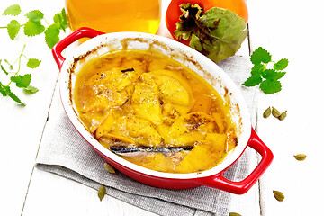 Image showing Persimmons baked with honey in pan on light board