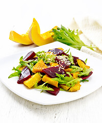 Image showing Salad of pumpkin and beetroot in plate on light wooden board