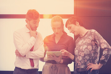 Image showing young business people group working on tablet computer with sunr