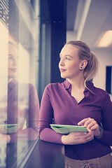 Image showing blonde businesswoman working on tablet at office