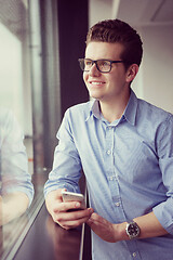 Image showing Businessman Standing In A Modern Building Near The Window With P