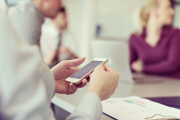 Image showing close up of  busineswoman hands  using smart phone on meeting