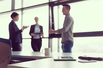 Image showing close up of tablet, business people on meeting in background