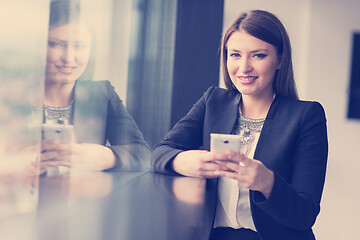 Image showing Business Girl Standing In A Modern Building Near The Window With