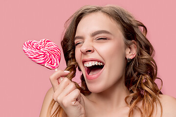 Image showing beauty portrait of a cute girl in act to eat a candy