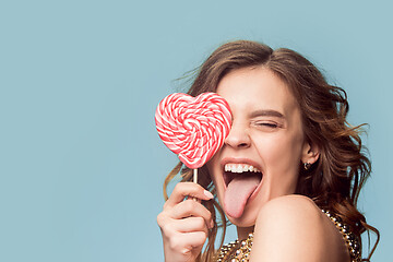 Image showing beauty portrait of a cute girl in act to eat a candy