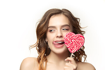 Image showing beauty portrait of a cute girl in act to eat a candy