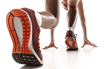 Image showing Portrait of young sporty woman at starting block of race isolated over white background