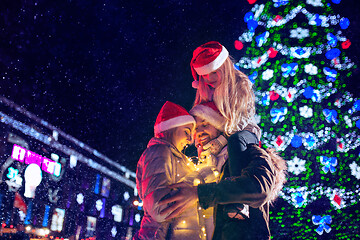 Image showing family, christmas, holidays, season and people concept - happy family over city background and snow