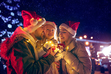 Image showing family, christmas, holidays, season and people concept - happy family over city background and snow