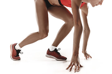 Image showing Portrait of young sporty woman at starting block of race isolated over white background