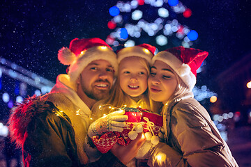 Image showing family, christmas, holidays, season and people concept - happy family over city background and snow