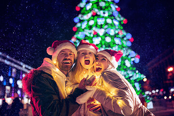 Image showing family, christmas, holidays, season and people concept - happy family over city background and snow