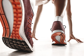 Image showing Portrait of young sporty woman at starting block of race isolated over white background