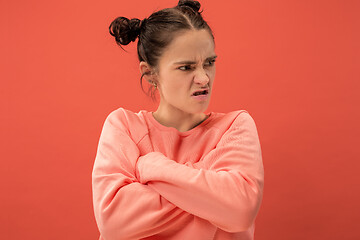 Image showing Portrait of an angry woman looking at camera isolated on a coral background