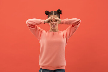 Image showing Portrait of attractive cute girl with bright makeup with love isolated over coral background