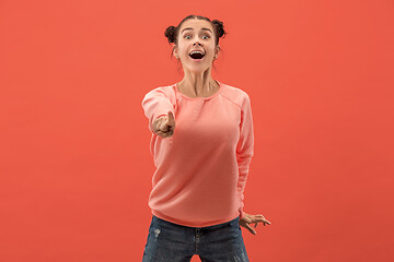 Image showing The happy business woman point you and want you, half length closeup portrait on coral background.