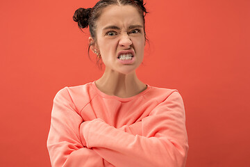 Image showing Portrait of an angry woman looking at camera isolated on a coral background