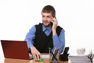 Image showing Manager negotiates by phone at his workplace on a white background