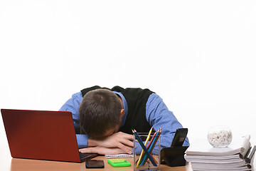 Image showing sleeping employee in the office at the table put his head on his hands