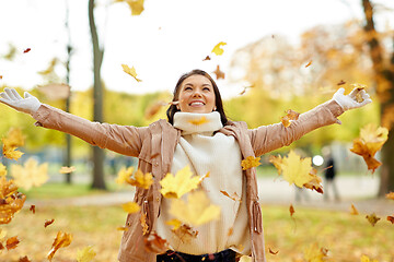 Image showing happy woman having fun with leaves in autumn park