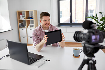 Image showing male blogger with tablet pc videoblogging at home