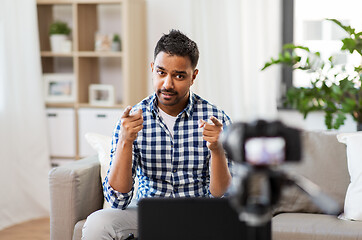 Image showing male blogger with camera videoblogging at home