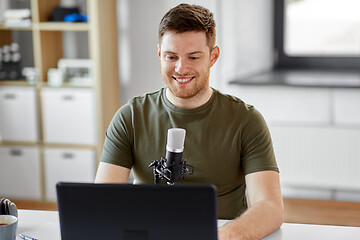 Image showing man with laptop and microphone at home office