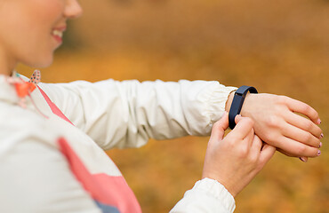 Image showing woman with fitness tracker outdoors in autumn