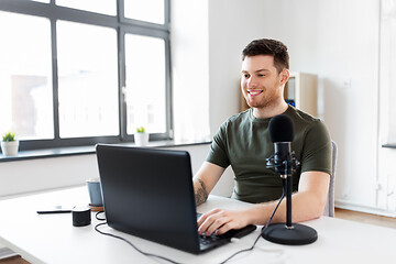 Image showing man with laptop and microphone at home office