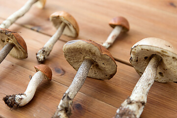 Image showing brown cap boletus mushrooms on wooden background