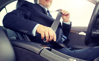 Image showing senior businessman fastening car seat belt