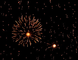 Image showing Fireworks exploding in black sky full of sparkles