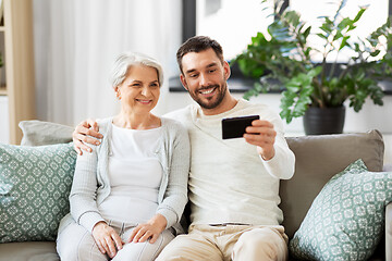 Image showing senior mother with adult son taking selfie at home