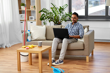 Image showing man with laptop computer after home cleaning